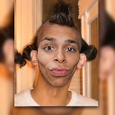 Person with a mohawk and pigtails making a wide-eyed, pursed-lip expression of confusion.