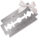 A stainless steel razor blade with a white ribbon tied to the top.