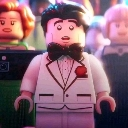 A Lego minifigure wearing a white tuxedo and black bowtie looks forward with a shocked expression.