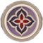 A circular emblem featuring a stylized four-petaled flower in red and purple shades.