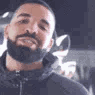 Drake nodding his head in a rhythmic, approving motion.