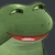 A green frog with a smug expression looking sideways.