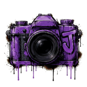 A DSLR camera covered in dripping purple paint with a large letter J on the side.