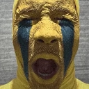 Person wearing a yellow mask with an open mouth and dark blue tears streaming down their face.