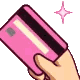 A hand holding up a pink credit card with small sparkles floating around it.