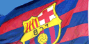 FC Barcelona flag waving in the wind against a blue sky.