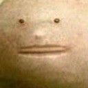 A grainy, low-resolution face with a blank, neutral expression staring directly forward.