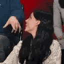 A woman turns to the camera and sticks her tongue out playfully.
