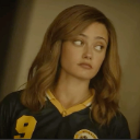A young woman in a sports jersey looking to the side with a skeptical and unimpressed expression.