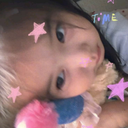 Person posing for a selfie with pink and blue star overlays on their face.
