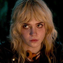 A blonde woman looking off-camera with a skeptical and unimpressed facial expression.