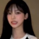 Young woman with dark hair looking at the camera with a strained, wide-eyed expression of disbelief.