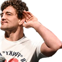 Man cupping his hand behind his ear in a mocking gesture of listening.