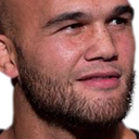 A man with a stubble beard looking slightly to the side with a confused and skeptical expression.