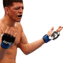 Nick Diaz with a confused expression throwing his hands up in the air while wearing MMA gloves.