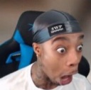 Man wearing a durag with wide, bulging eyes and an open mouth expressing extreme shock.