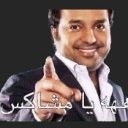 A man in a suit pointing his finger directly at the viewer with a smug smile.