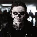 Tate Langdon wearing skull face paint stares intensely at the camera.
