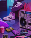 A boombox and cassette tapes sit on a floor in a room lit with vibrant purple neon light.