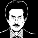 Man with a thick mustache and suit staring with a serious and suspicious expression.