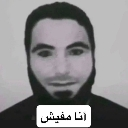 A black and white portrait of a bearded man with a serious expression and an Arabic caption box below.