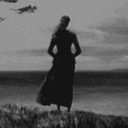 A woman standing on a cliff edge transforms into a bird and flies away in a black and white animated sequence.