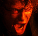 A man with a distorted, screaming face illuminated by a harsh red light.