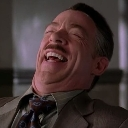 J. Jonah Jameson laughing with his head tilted back and eyes closed.