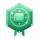 A green hexagonal badge with a central gem and small ribbons hanging from the bottom.