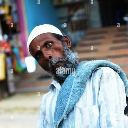 An older man with a white beard and skullcap looking directly at the camera with a confused and skeptical expression.