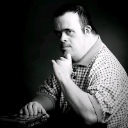 Man resting his chin on his hand with a serious and contemplative expression.