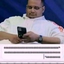 Man with glasses looking down at his smartphone with a serious expression while typing.