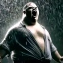A man with an open mouth screaming while standing in heavy rain.