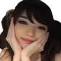 A woman resting her chin on her hands with a shy, happy smile.