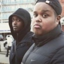 Two men looking directly at the camera with skeptical and unimpressed expressions.