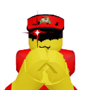 A blocky yellow character with a sinister grin and glowing red eyes holding its hands together in a plotting gesture.