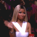 Nicki Minaj waving her hand back and forth in a repetitive, dismissive motion.