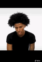 A man with an afro looking around with a skeptical and judgmental expression.