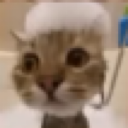 A brown tabby cat with wide, dazed eyes wearing a large, poofy white hat.