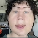 Human face with heavy wide-angle distortion creating a humorous and surreal appearance.
