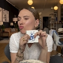Scarlett Johansson making a kissing face while holding a small white object.
