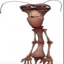 A brown, distorted, alien-like creature with multiple eyes looking down with a confused and weary expression.