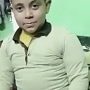 A young boy looking at the camera with a neutral expression.