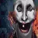 A distorted human face with wide, intense eyes and a massive, toothy grin.