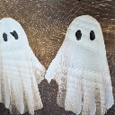 Two hand-drawn white ghosts with black eyes holding hands against a brown textured background.