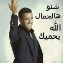A man in a tuxedo waving his hand with Arabic text beside him.