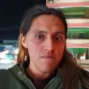 Man with long hair staring with a serious and unimpressed expression.