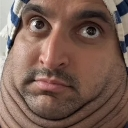 Man with a double chin looking directly at the camera with wide, startled eyes.