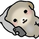 A small, rounded creature lying on a pillow while holding a smartphone and looking at the screen.