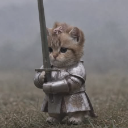 A small kitten wearing metal knight armor stands holding a sword in a misty field.